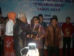 Coordinating Economic Minister Hatta Rajasa (left) presents Paramakarya Award to CEO of PT Asindo Tech Fidrianto, witnessed by Manpower and Transmigration Minister Muhaimin Iskandar (right). The award was presented in Jakarta on November 24, 2013.